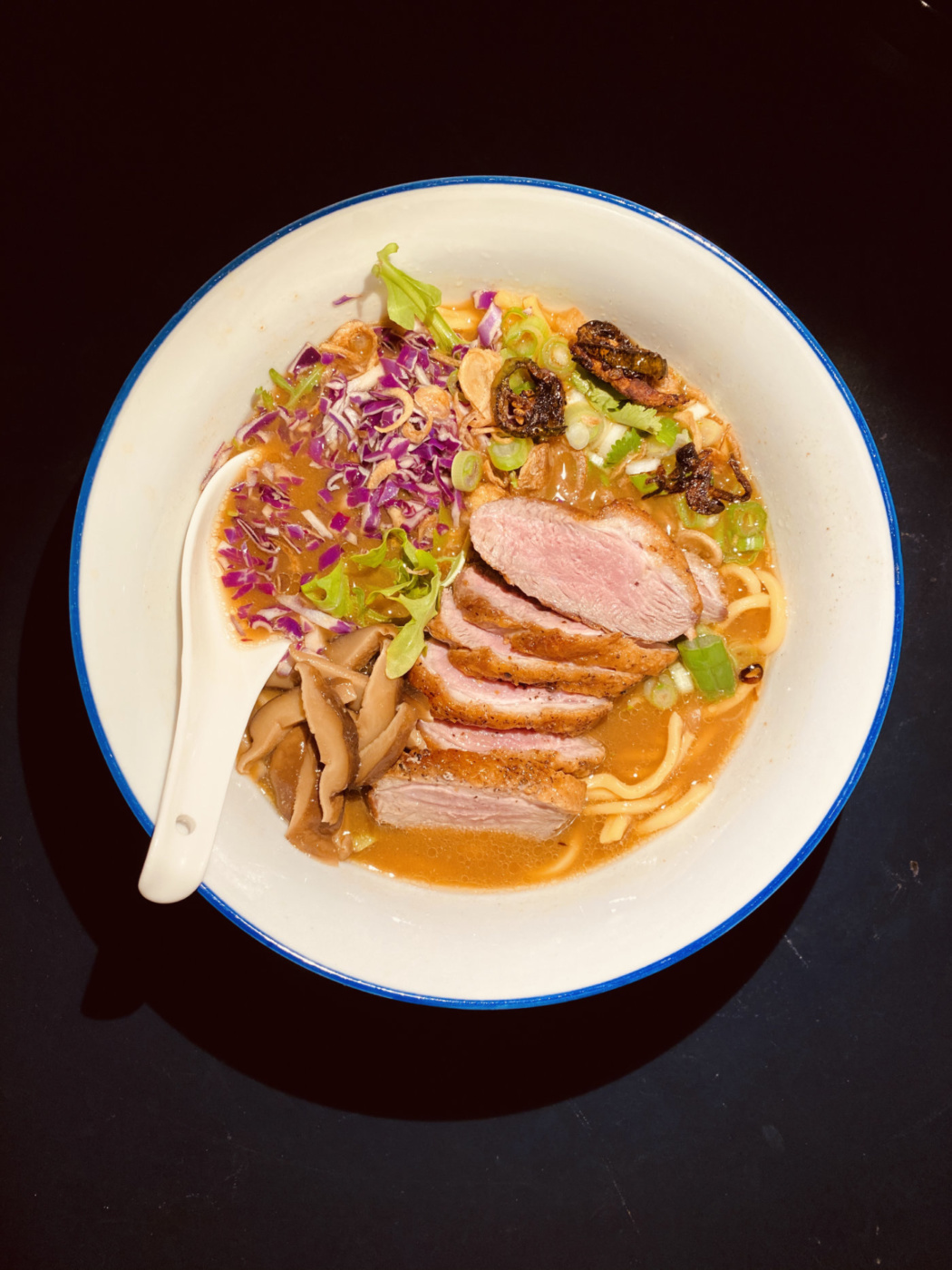 A long simmering broth made of Shiitake mushrooms and Miso, topped off with thinly sliced crispy seared duck breast, fried shallots and jalapeño, arugula, red cabbage, scallions, cilantro and truffle oil. Try also to substitute arugula for some charred bok-choy or gai-lan.