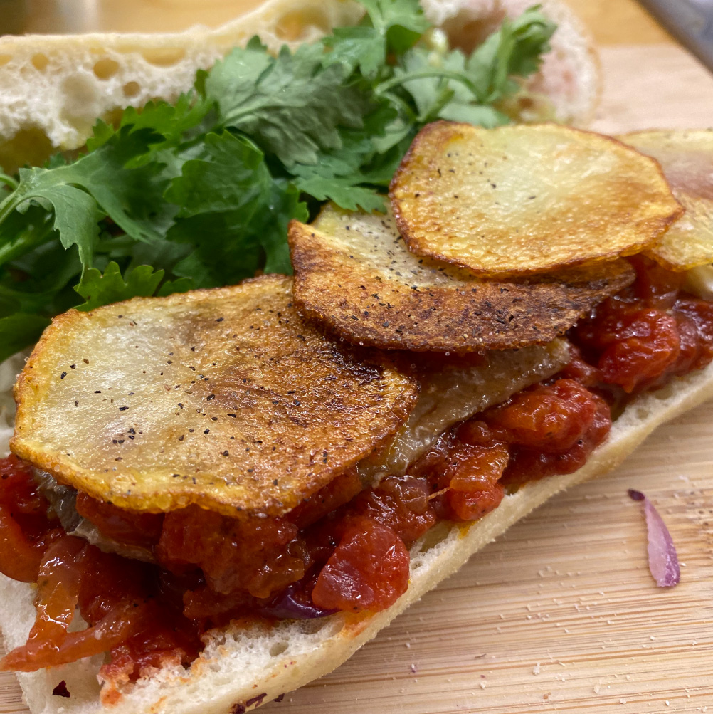 This delicate flavor rich, intricate yet comforting, light but fulfilling sandwich will delight the adventurous palate. Made of homemade chips, sardines, cilantro and a tomato and onion confit wait... show don't tell, did you try one yet?